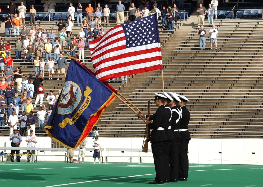 A man salutes during the national anthem before a baseball game