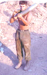 Specialist 4 Tom Garvey carrying 105mm shells in Vietnam.