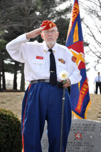 Photo of Marine Corps Veteran Jerry Ingram saluting at a remembrance ceremony.