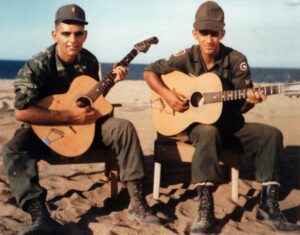 Image of 2d Lt Jordan Klempner and Billy playing guitar on the beach at Tuy Hoa in 1967