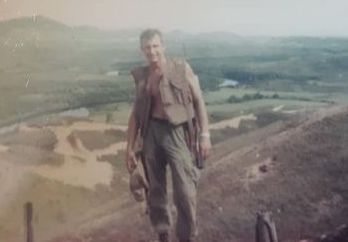 Kenny Esmond with the South Vietnamese countryside behind him.