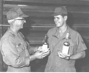 Dean Moss receiving two trophies