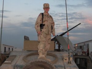 Ashley (Pullen) Hawkins standing on a Humvee in Iraq