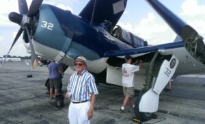 Joe Dwigans standing in front of a Commemorative Air Force Helldiver