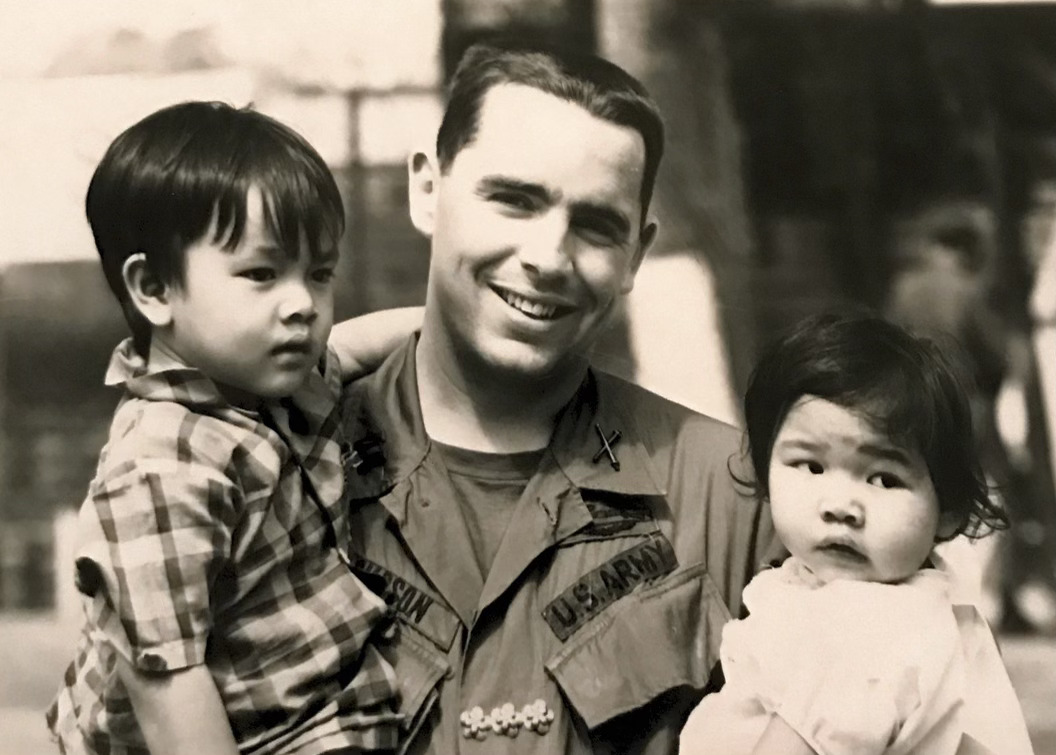 U.S. soldier in South Vietnam holding two children from the local village