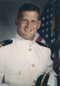 A male Navy Ensign in his choker white uniform