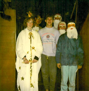 People wearing Christmas costumes in Germany, including a Santa Claus mask and an angel costume.