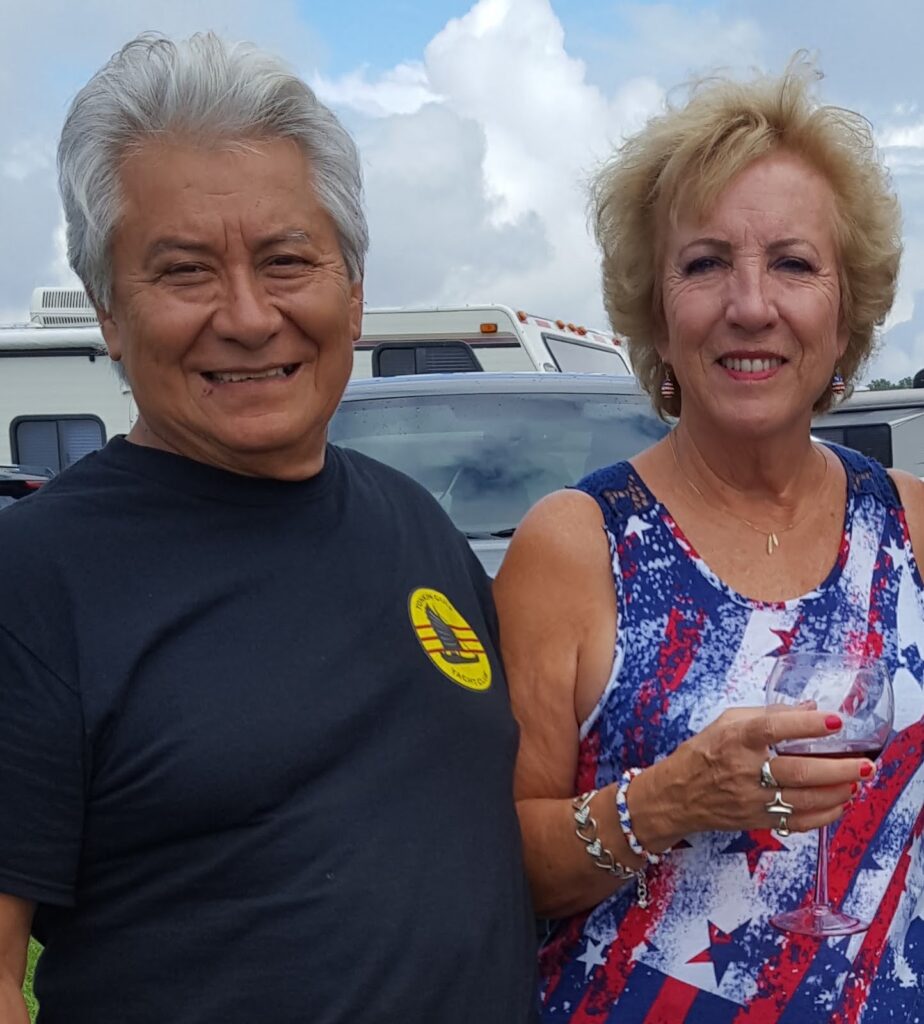 A husband with his wife who is drinking a glass of wine