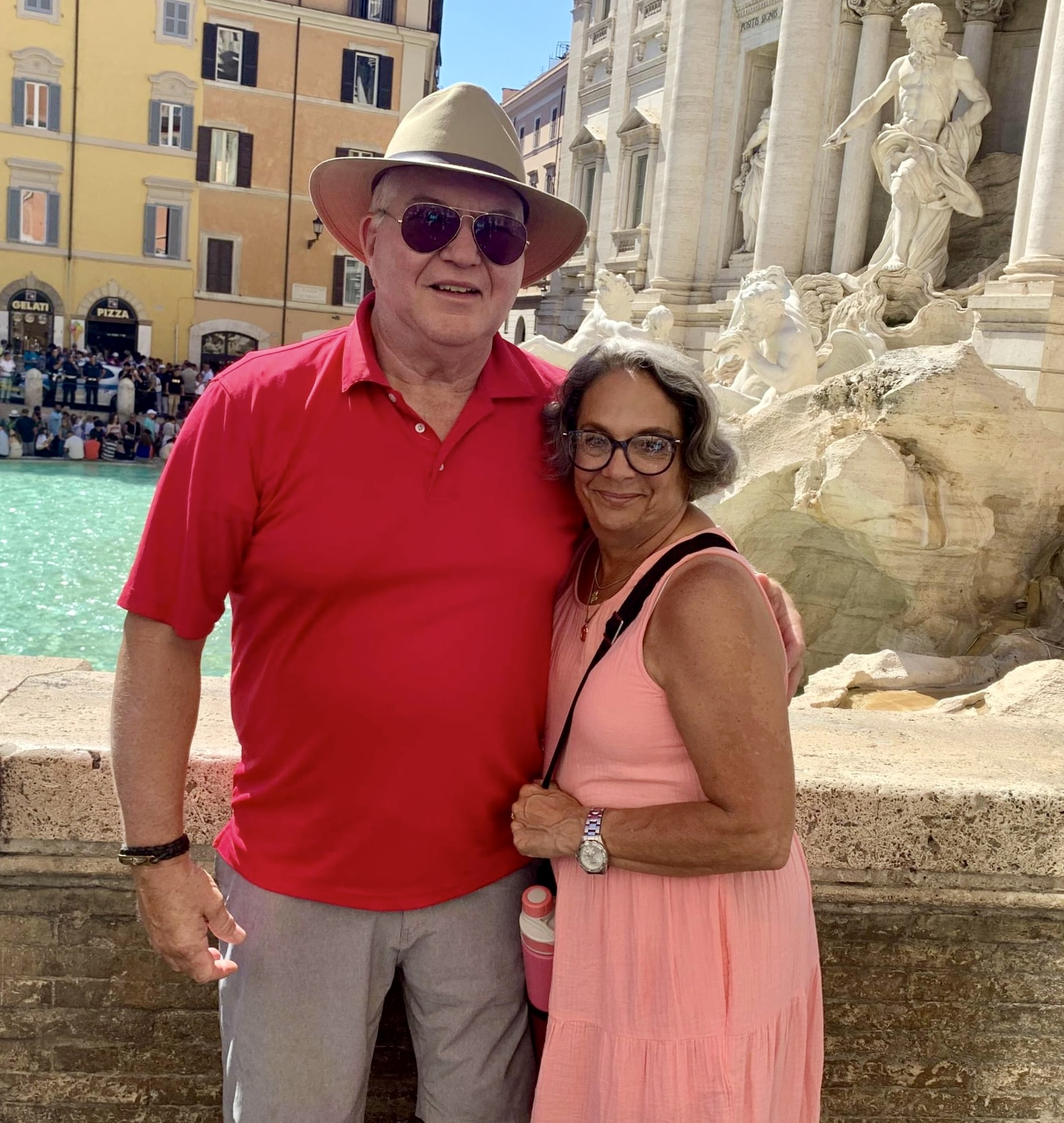 Husband and wife posing for a photo in front of Trevi Fountain