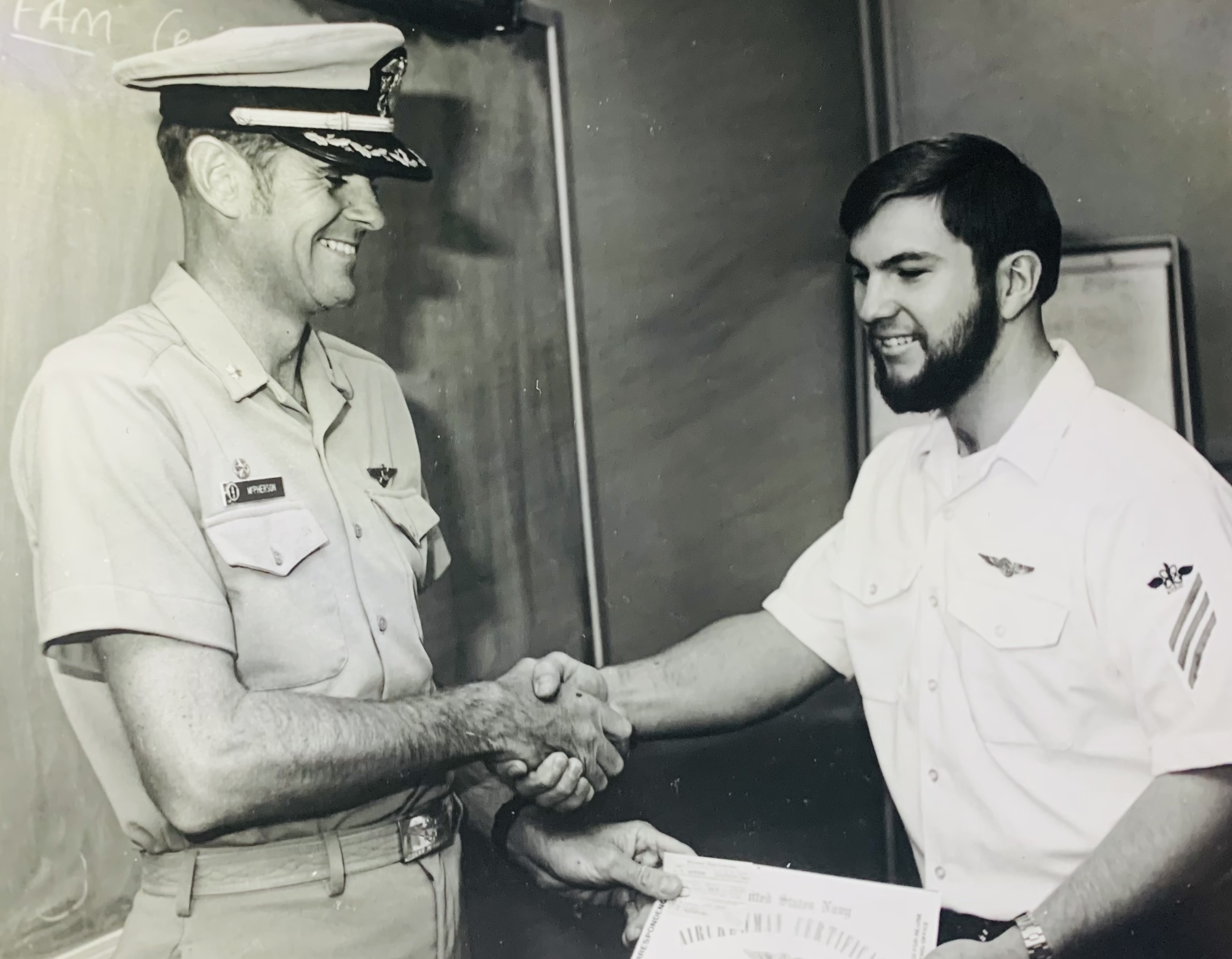 Navy officer shaking hands with an enlisted sailor