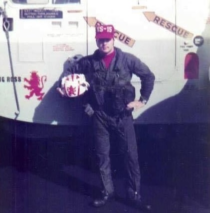 U.S. sailor standing in against the side of a helicopter