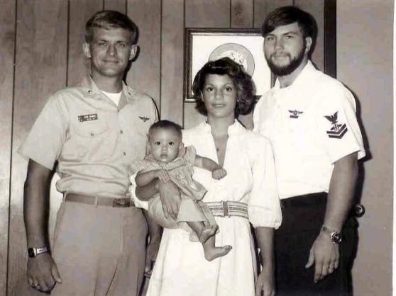 Navy officer with enlisted sailor and the sailor's wife and baby