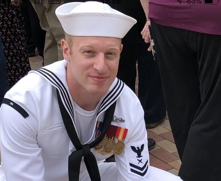 U.S. Navy sailor in his summer white uniform with large medals