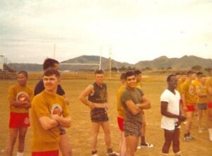 Marines in workout gear getting ready to exercise on a football field