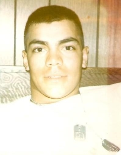 A young male U.S. Marine in a white t-shirt wearing his dog tags