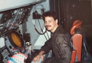 Navy sailor sitting in front of electronic equipment