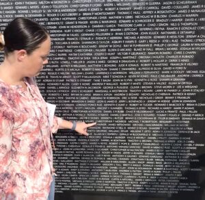 Woman pointing to name on Iraq War memorial wall