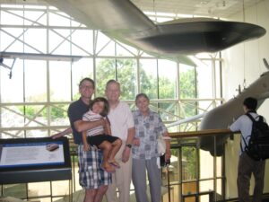 Four family members standing in front of a drone hanging from the ceiling of a museum