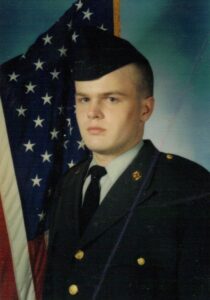 Male U.S. Army soldier in front of a U.S. flag