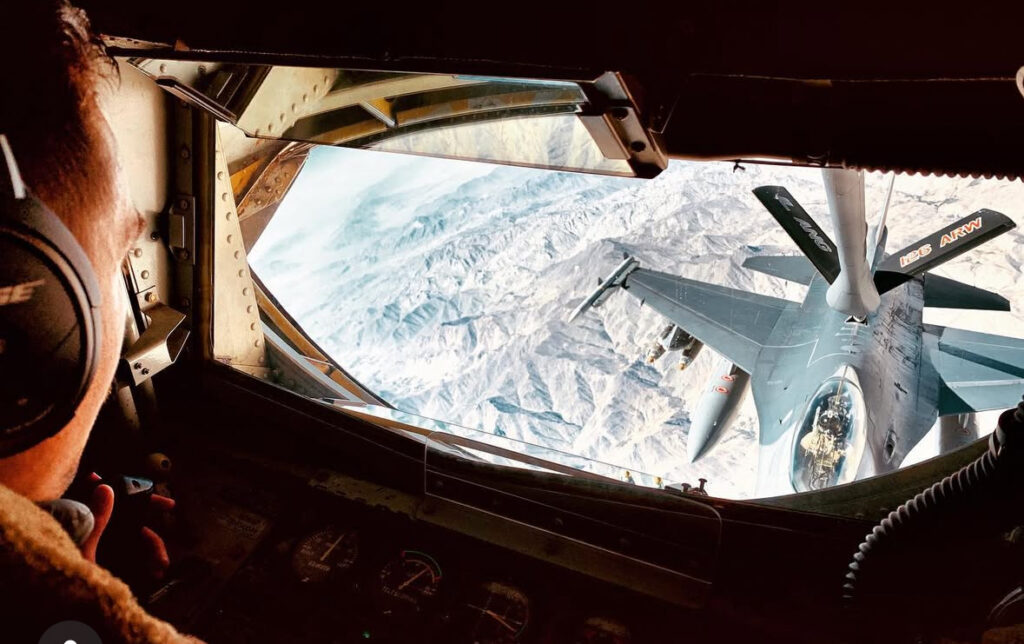 Airman controlling the boom of a KC-135 to refuel an F-16.