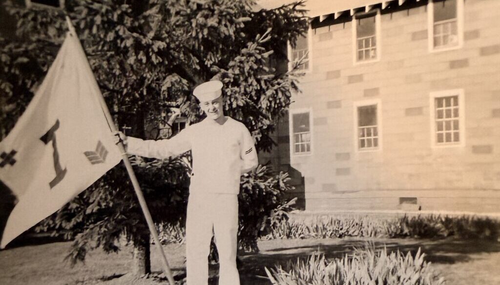 Sailor in uniform at boot camp holding company flag
