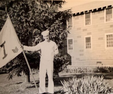 Sailor in uniform at boot camp holding company flag