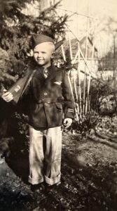 Boy in an army uniform with a rifle over his shoulder