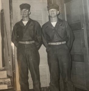 2 male Marines in uniform standing at ease.