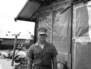 Male Marine in uniform standing outside a building in Vietnam